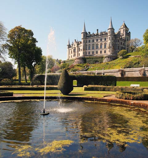 Looking up from the pond and water-feature of the formal gardens to cliff-top turreted Dunrobin Castle