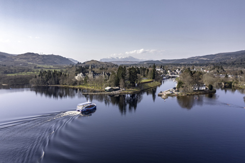 Ariel view of a cruise boat arriving back in Fort Augustus from Loch Ness