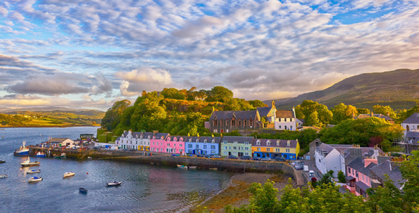 Portree harbour surrounded by colourful buildings seen at sunset