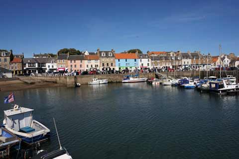 Colourful buildings overlook the boats in Anstruther Harbour on a sunny day