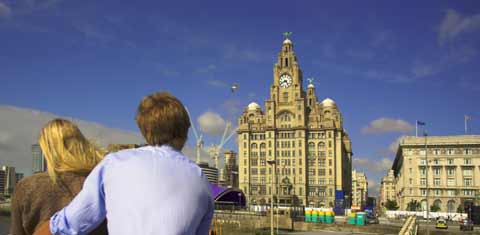 Couple view the Liverpool Waterfront from the deck of a ferry