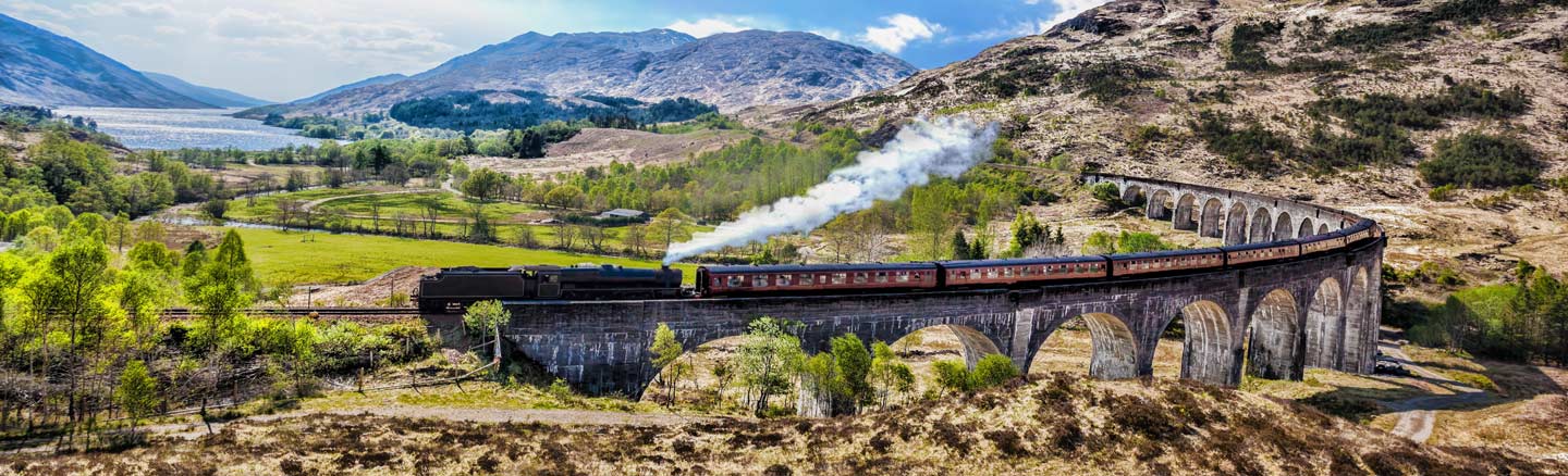 The Jacobite Steam Train crosses the Glenfinnan Viaduct with Loch Shiel in the background