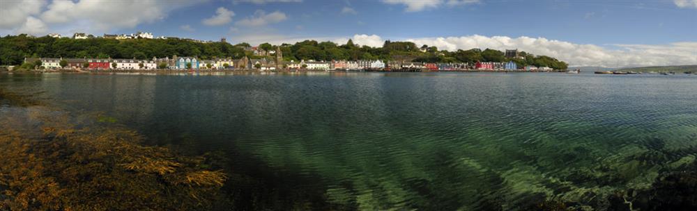 The colourful houses of Tobermory seen from across the crystal-clear waters of Tobermory Bay