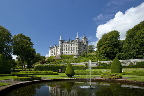 Fairytale Dunrobin Castle overlooking the formal gardens with a pond and waterfall in the foreground