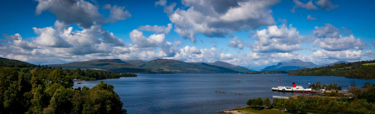 Panorama of Loch Lomond showing the Maid of the Loch paddle steamer and the mountains of the Arrochar Alps