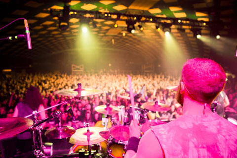Drummer in forground playing to large crowd in background at Barrowlands