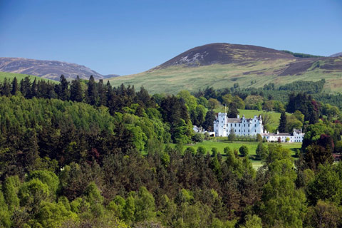 Blair Castle - striking white castle set amongst verdant woodland with hills in background