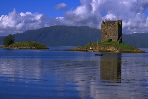 loch and mountains on beautiful bright day with small square castle atop a small island