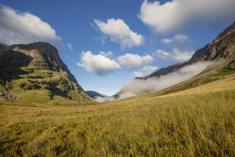 Clouds swirl around the Three Sisters of Glen Coe mountain range