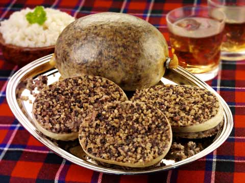 A platter with haggis and a glass of whisky on the side
