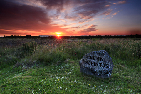 The Clan Mackintosh memorial stone seen at desolute Culloden Moor at sunset