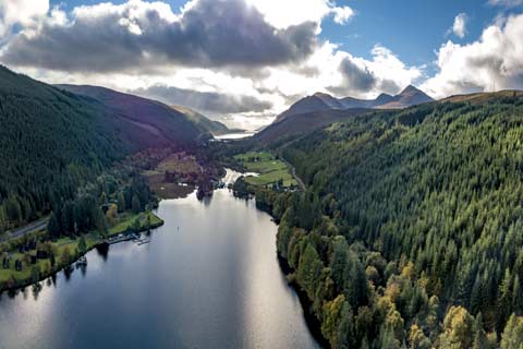 The tree-clad mountains of the Great Glen surround Loch Oich and the bridge over the Caledonian Canal