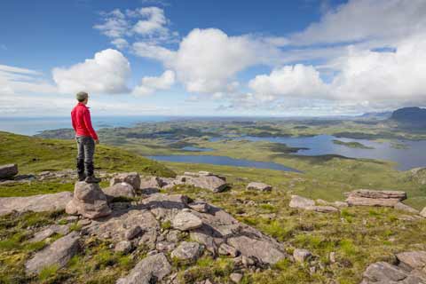 A walker takes in the view from the summit of Stac Pollaidh