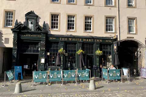 View of the White Hart Inn with seats and tables outside