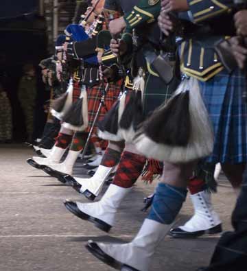 Marching pipers wearing colourful kilts