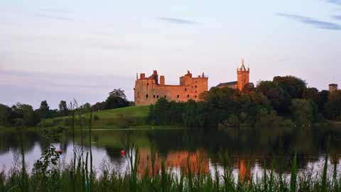 Linlithgow Palace seen across the lake at sunset 