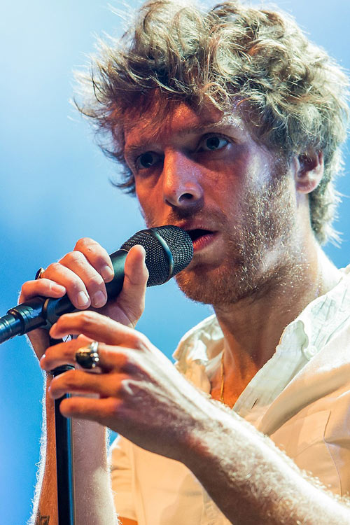 Close up head and shoulder shot of Paolo Nutini holding and singing into a microphone