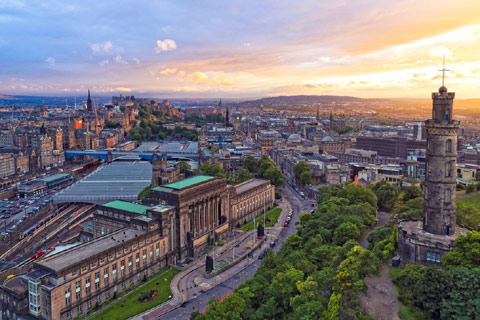 looking down on to Edinburgh cityscape with sun setting in background