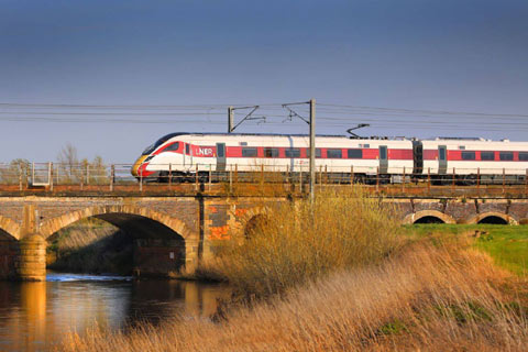 LNER train crossing a river over a bridge