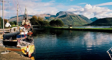 Fort William - boats moored alongside calm loch with mountains in background