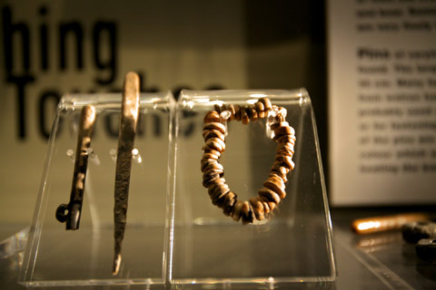 tools and jewellery made from bone in a museum display case