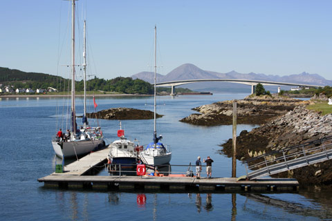 little boats in harbour at Lochalsh with modern bridge over to Skye in background